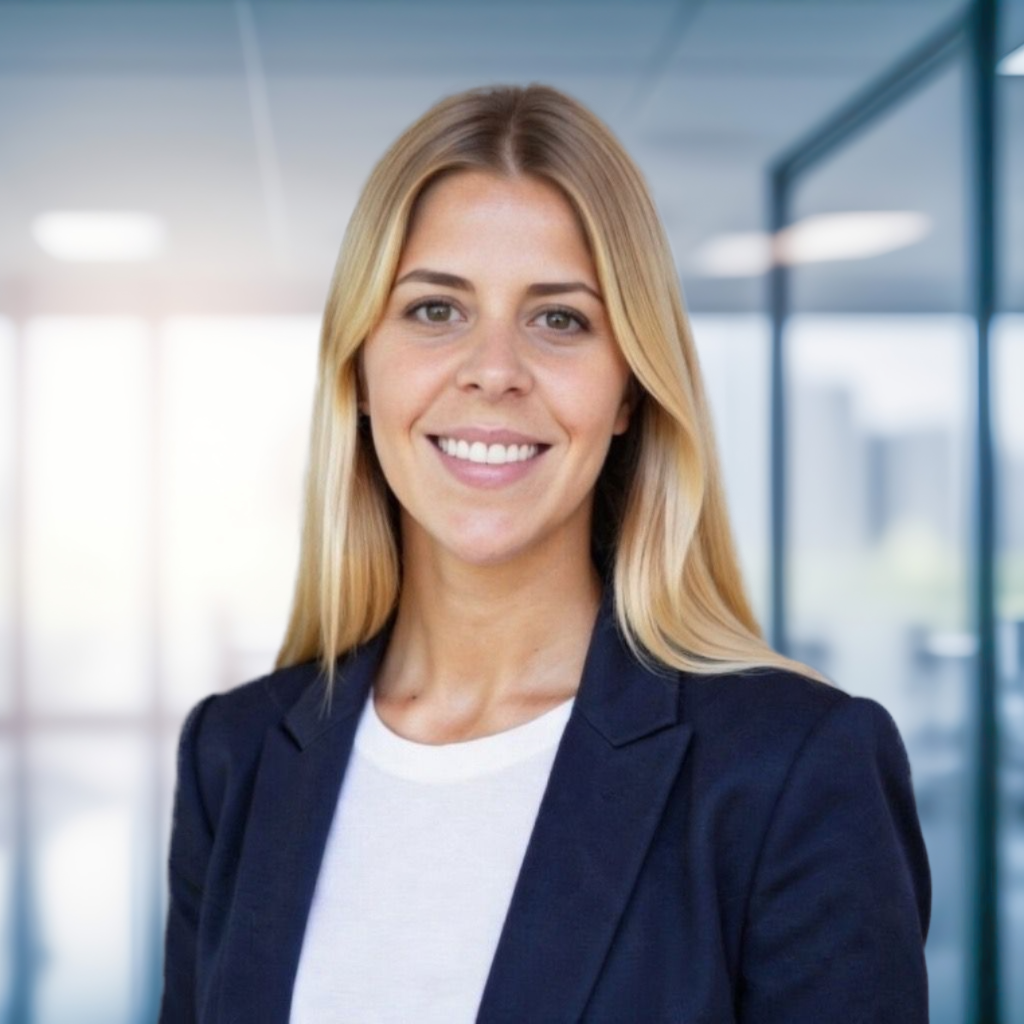 Professional woman in business attire smiling in modern office setting.