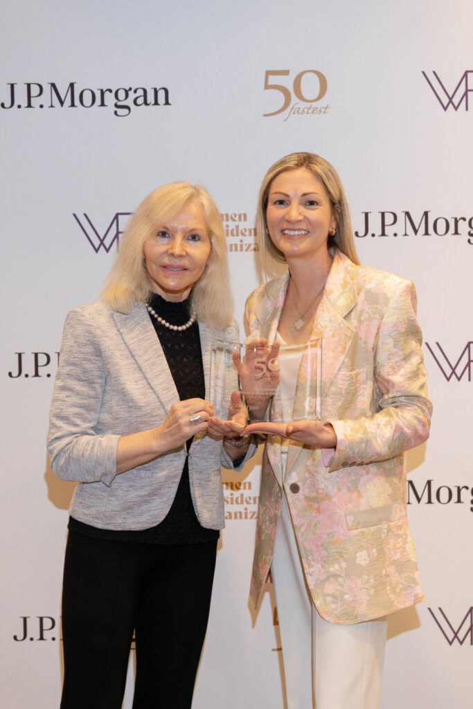 Two women holding an award at the SDI event celebrating women-led companies.